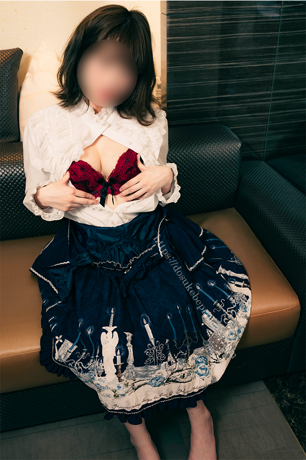 ロリータファッションの服を着てブラジャーを見せるポーズをとる女の子