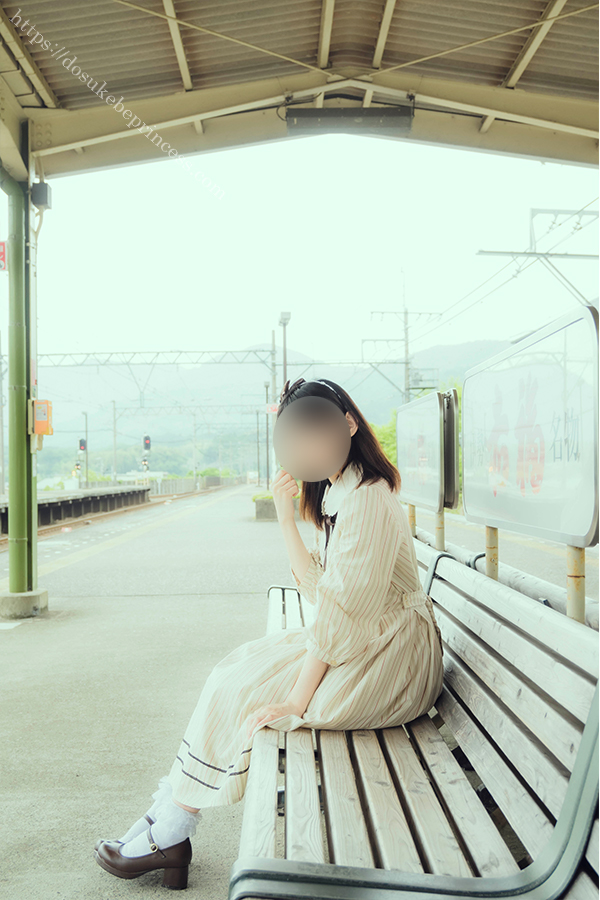 駅のホームのベンチに座るロリータ服の女の子
