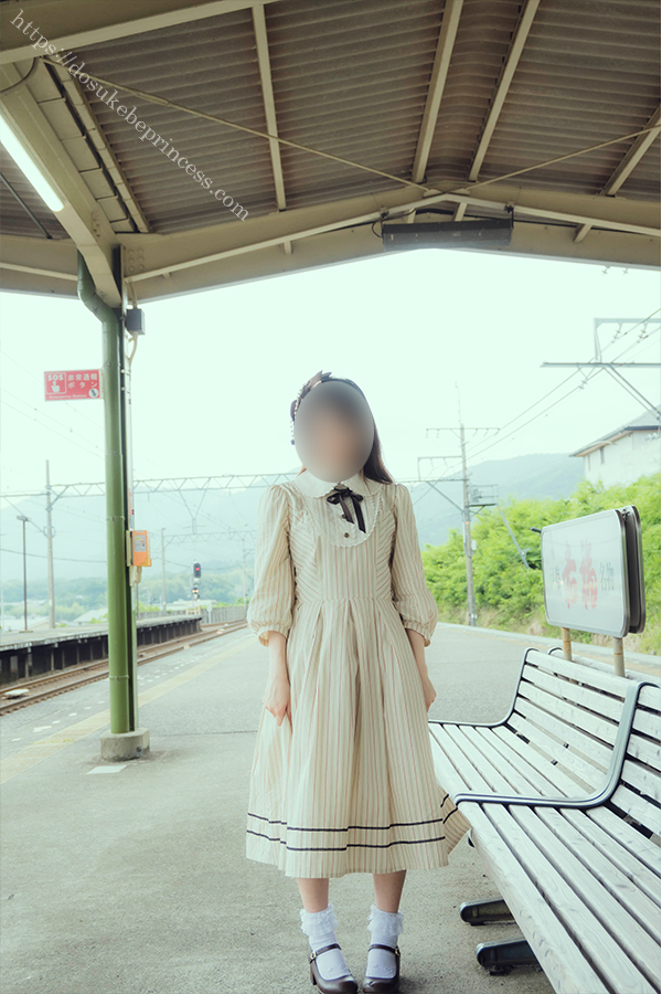 駅のホームのベンチに座るロリータ服の女の子