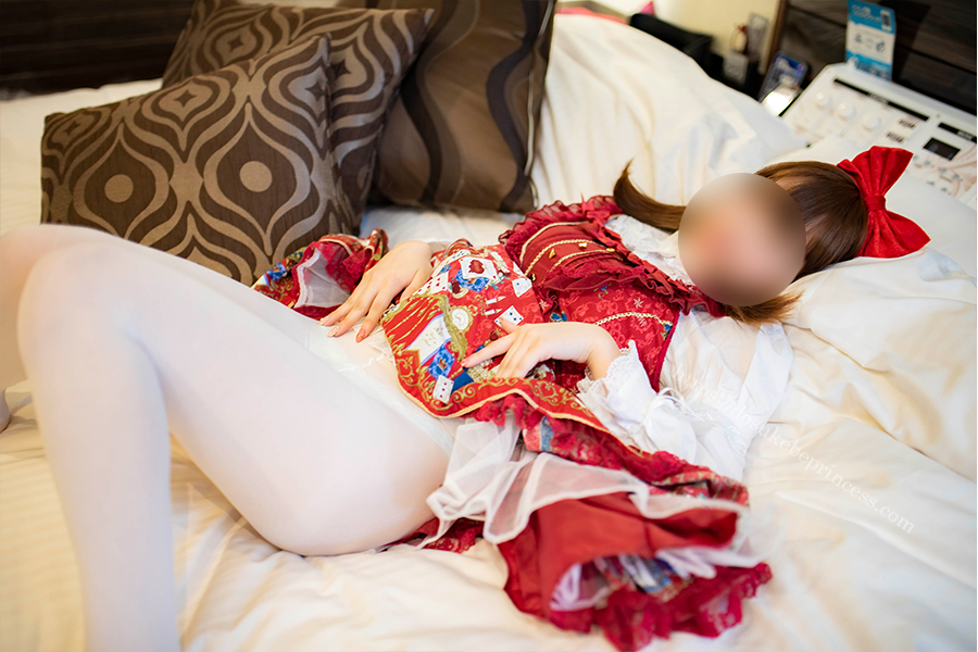 赤いロリータ服を着てベッドに寝そべる女の子