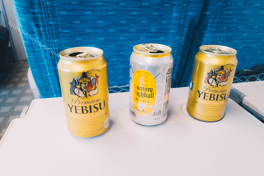 新幹線のテーブルに並んだビールとハイボールの空き缶