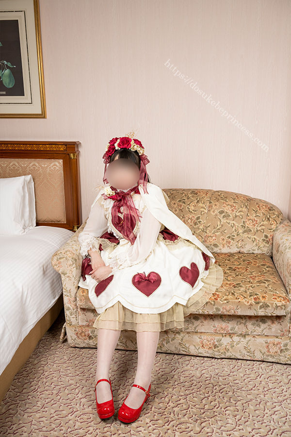 ロリータ服を着てホテルのベッドの上でポーズをとる女の子