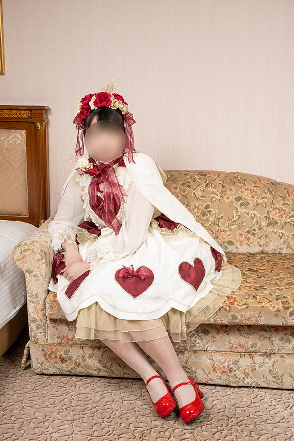 ロリータ服を着てホテルのベッドの上でポーズをとる女の子