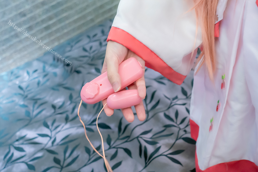 桜ミクコスプレ姿でピンクローターを持つコスプレイヤー