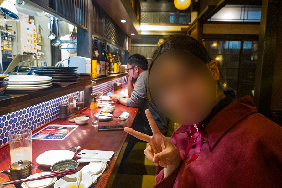 はち丸 金沢駅前店のカウンター席でポーズをとる女の子
