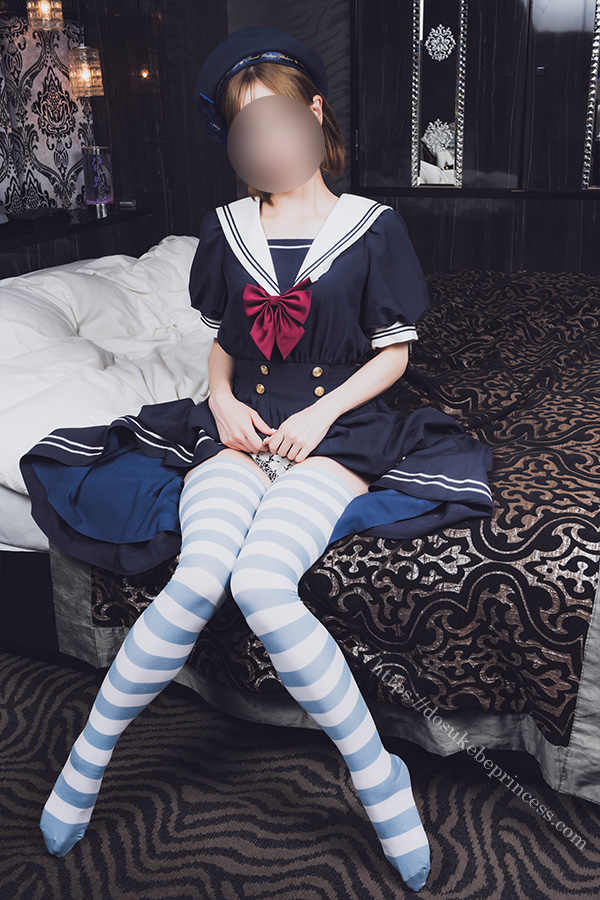 ベッドに座ってセーラーロリータ服のスカートをまくりパンティを見せる女の子